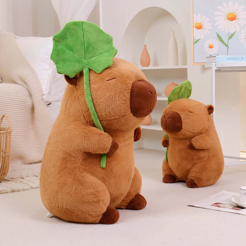 Plush capybara holding a leaf