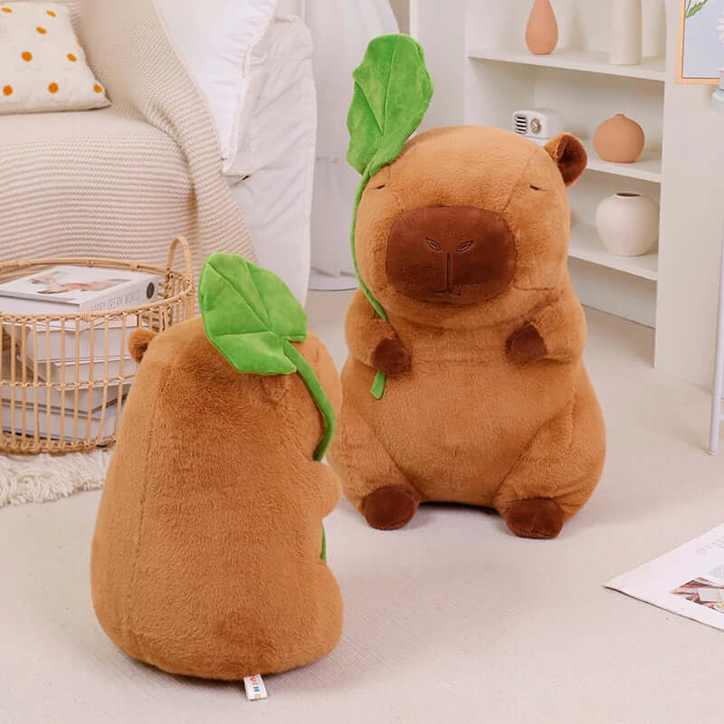 Plush capybara holding a leaf