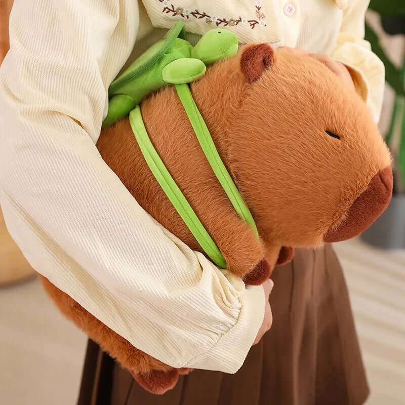 Plush capybara with turtle backpack on the hand of woman