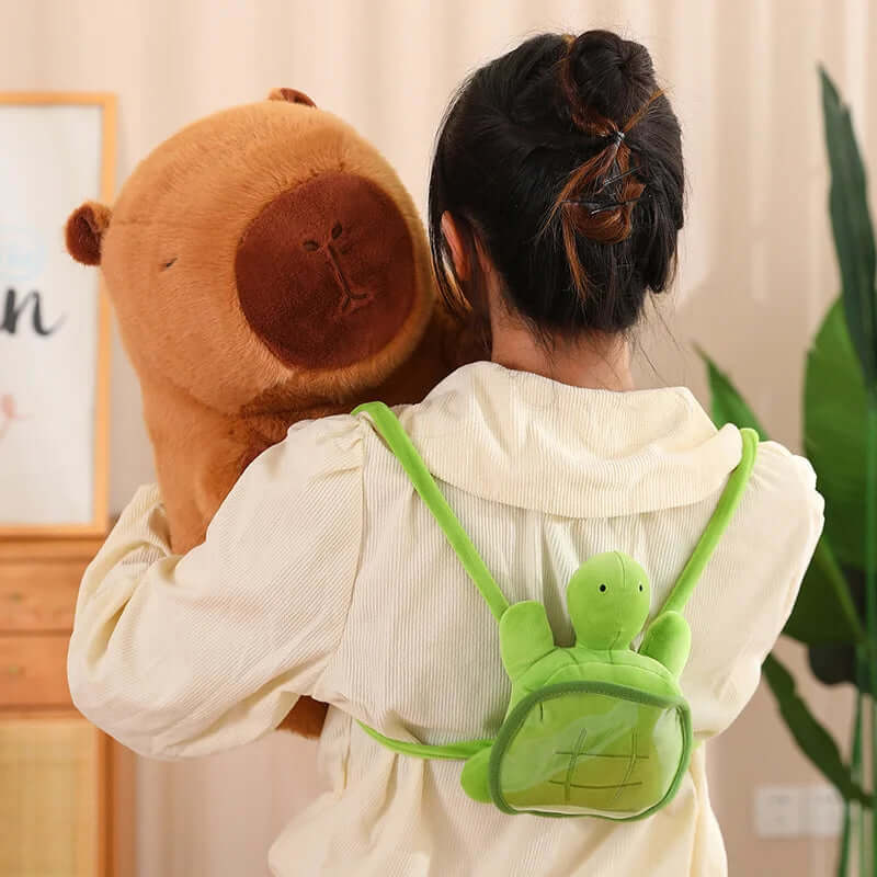 Plush capybara with turtle backpack on the hand of woman